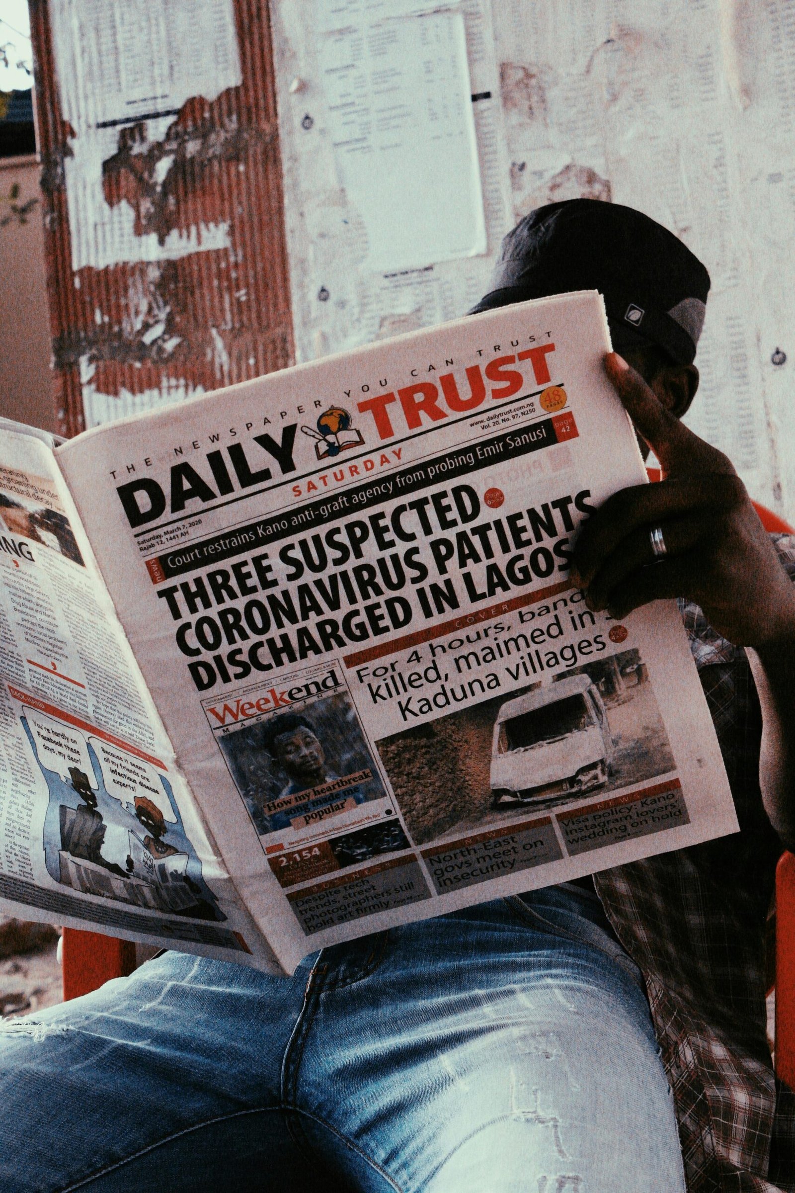 A man reads a newspaper indoors, highlighting current events and lifestyle.